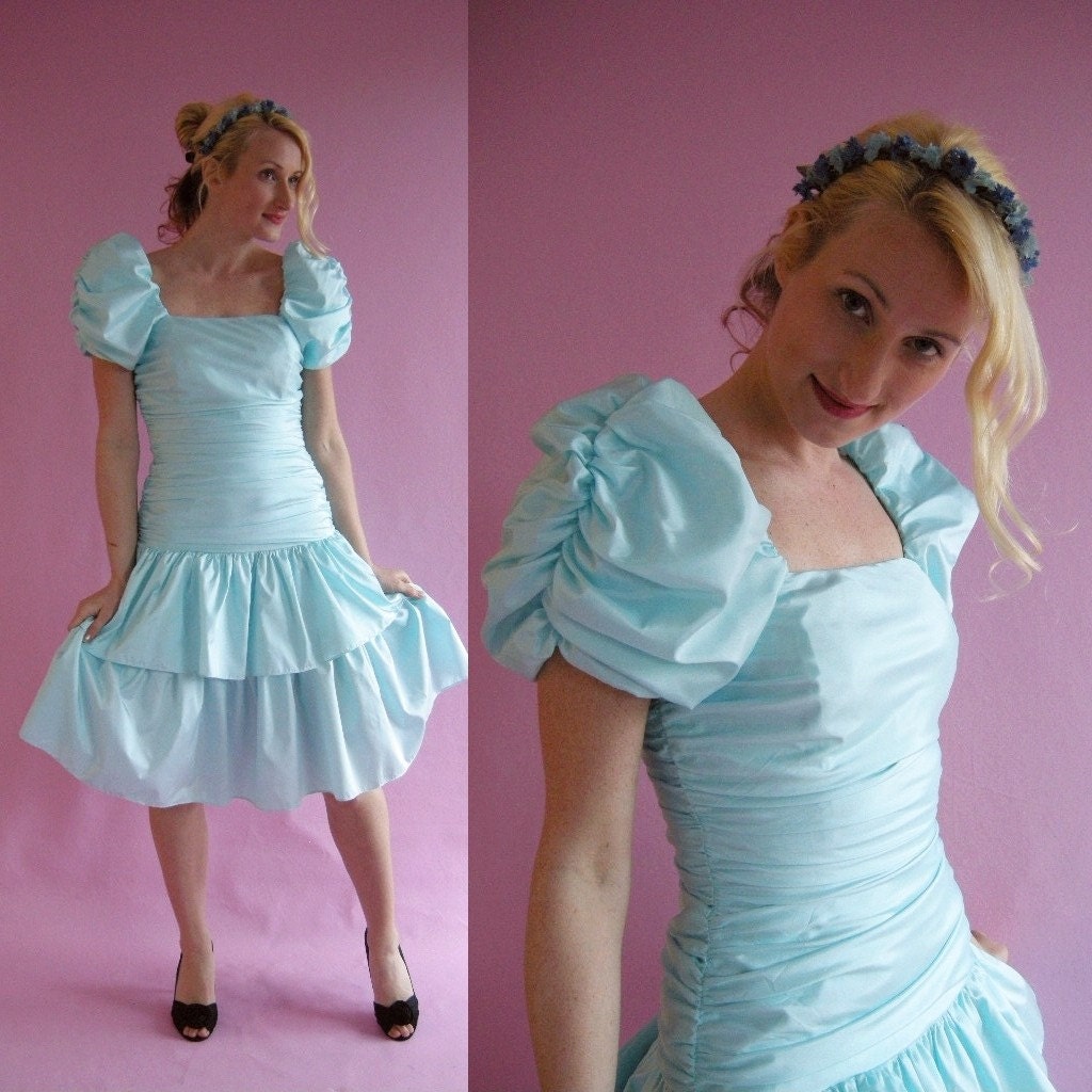 Light blue party dress with puffed sleeves from the 80s. Model is white thin and blonde.