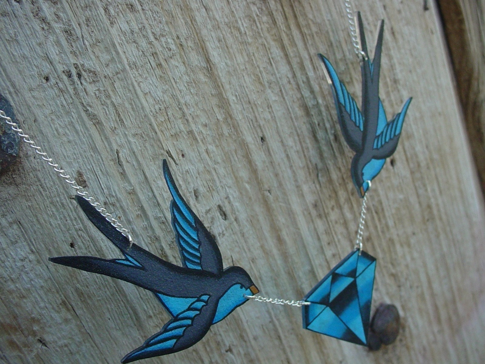 tattoo inspired blue and grey sparrows holding diamond necklace