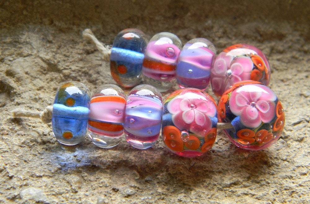 9 beautiful lampwork encased beads, created with clear, pink, coral, white and blue glass. 
