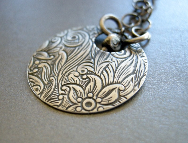 handmade necklace with embossed flowers on oxidized sterling silver