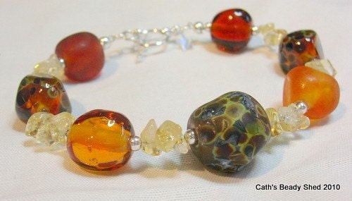 This bracelet features 7 hand-shaped nuggets of lampwork glass, with sparkly semi-precious citrine tumble chips strung in between.