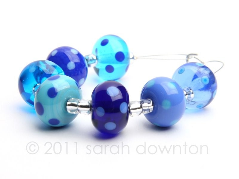 set of 7 beads in transparent and opaque blues and turquoise all decorated with coordinating colour dots