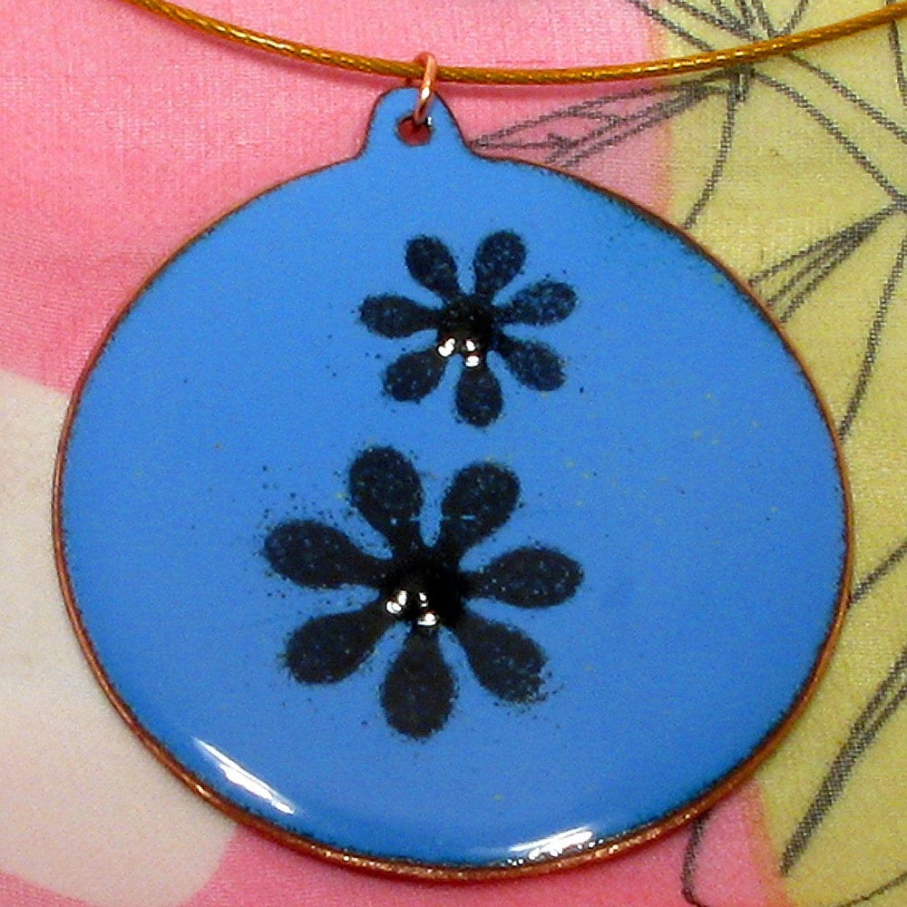 A bright and breezy lavender blue and black enamel on copper pendant with a daisy motif. 