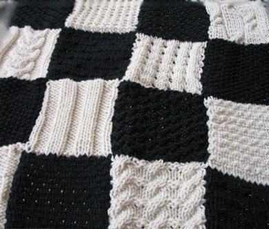 Small black and white hand-knitted blanket in many patterns for a favorite 